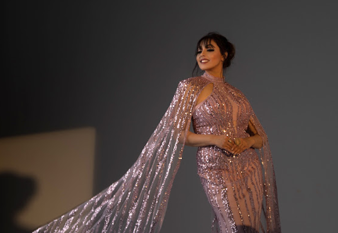 Ishha walking the runway in a sequinned cape gown